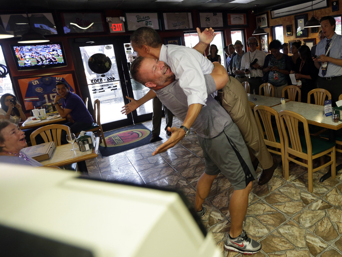 President Obama is lifted off the ground by Scott Van Duzer, owner of Big Apple Pizza and Pasta Italian Restaurant, during an unannounced stop Sunday in Fort Pierce, Fla. Photo by Pablo Martinez Monsivals/AP
